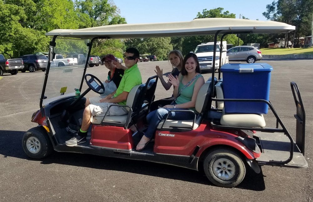 Family riding on golf cart to their Canton, TX cabin