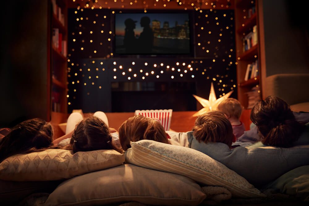 A family lays on cushion, only their heads visible, during their East Texas movie night at Mill Creek Ranch Resort.