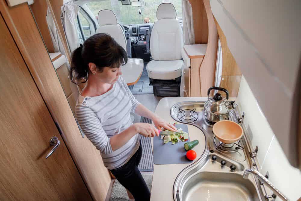 A woman can be seen enjoying an East Texas spring break getaway to Mill CReek Ranch Resort, prepping her ingredients for her campfire recipe.